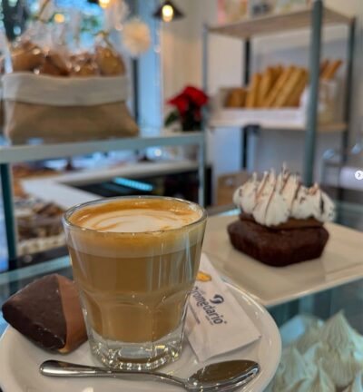 Cafe con leche en vaso y un pastelito de chocolate